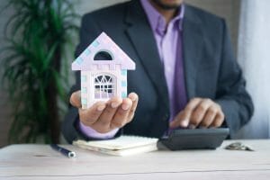 Business Man Holding Tiny House